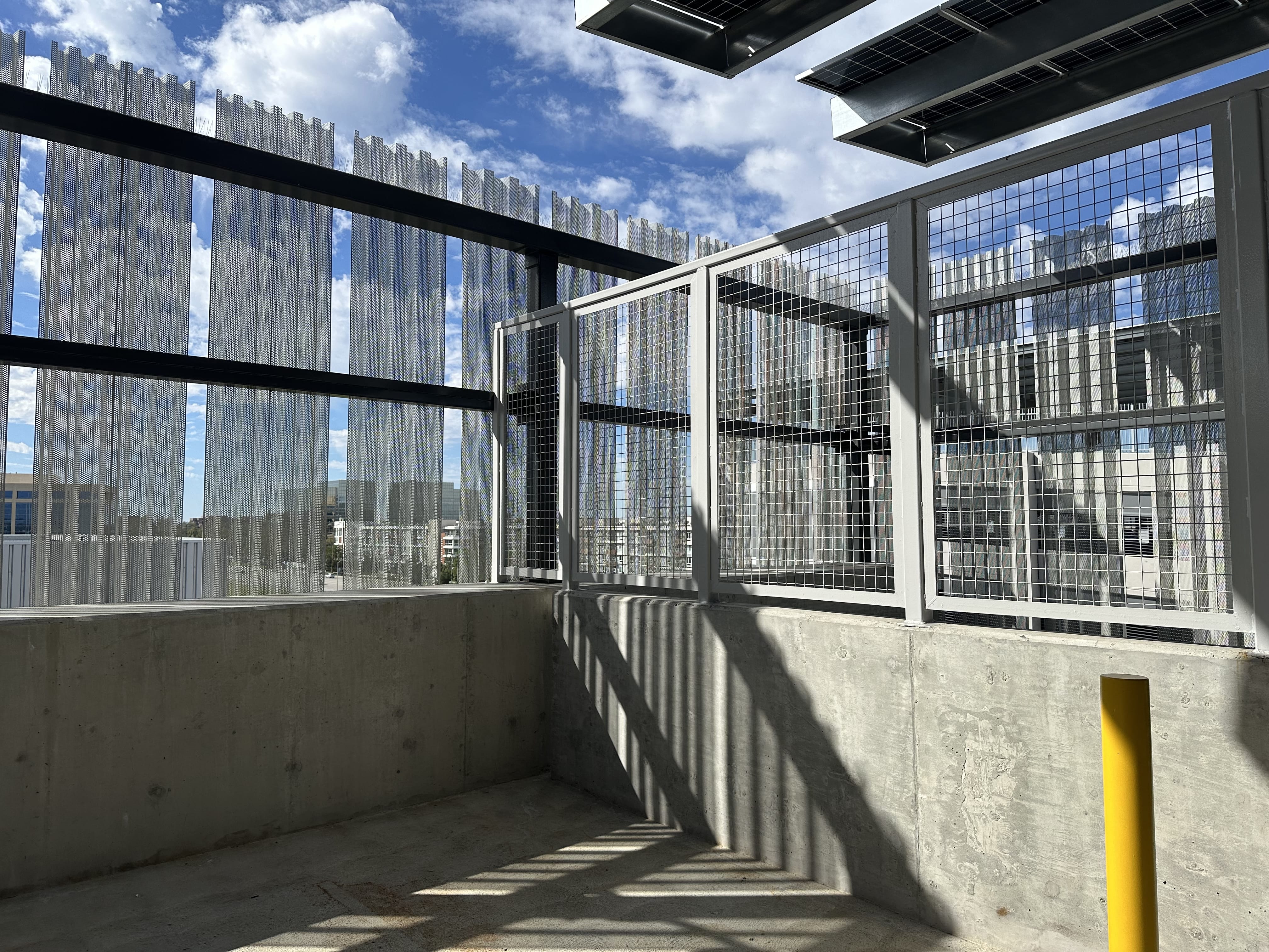 Mesh steel railings against blue sky on a parking deck