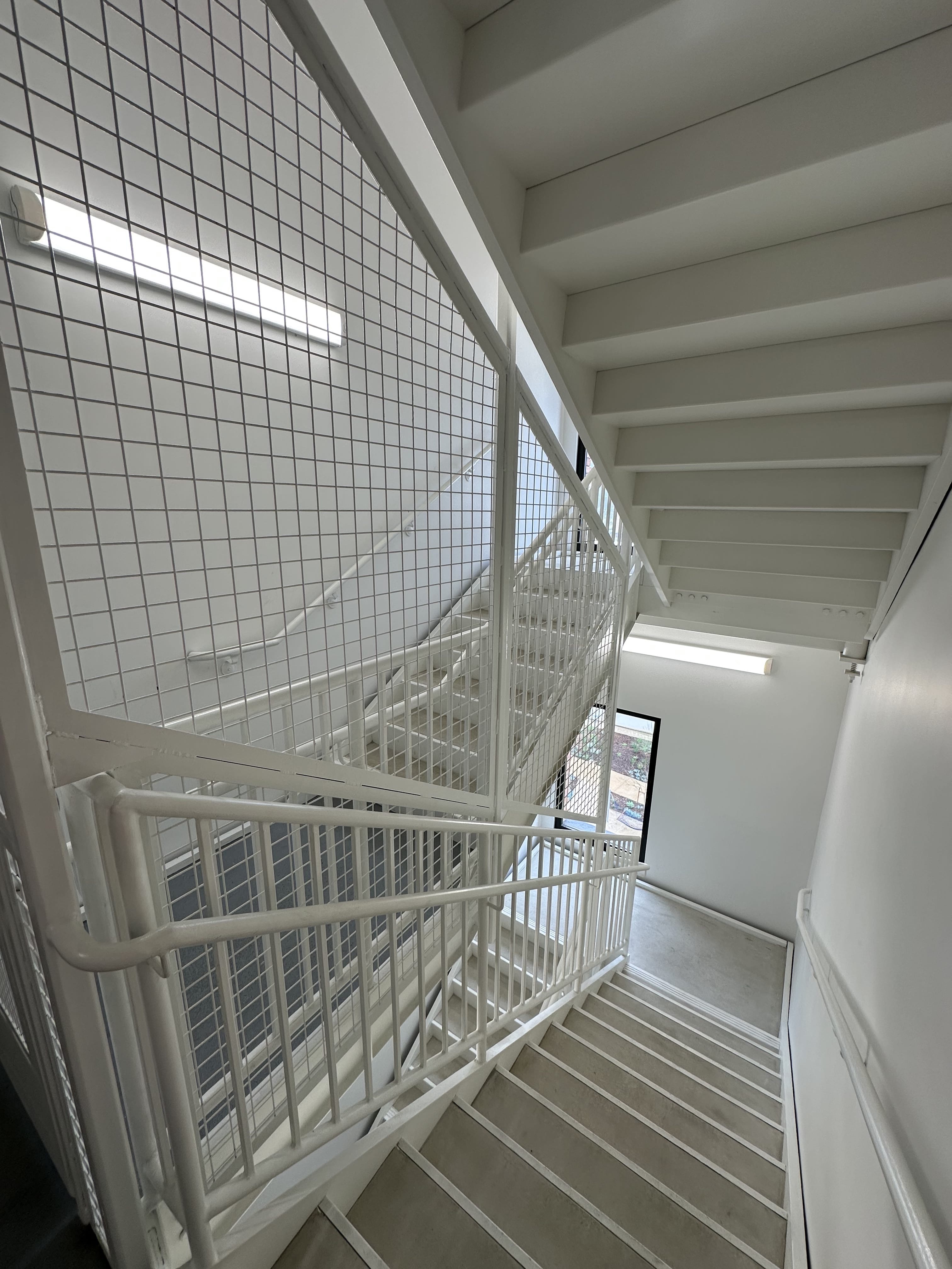 Interior stairwell with white-painted mesh railings